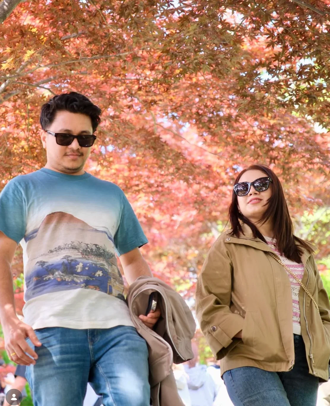 Suyog and a companion beneath colourful autumn leaves