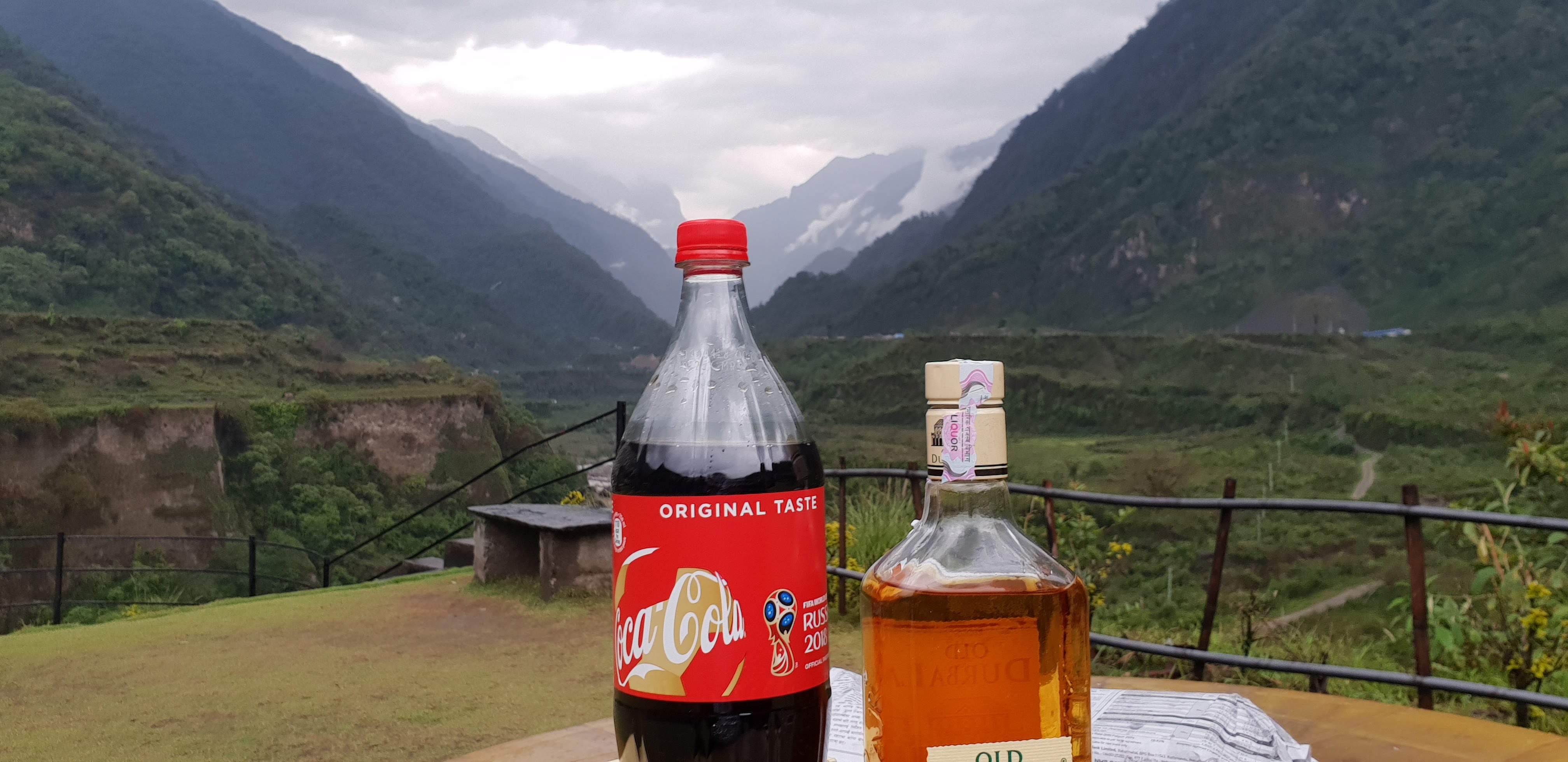 A terrace overlooking the green hills and cloud-covered mountains at Tatopani
